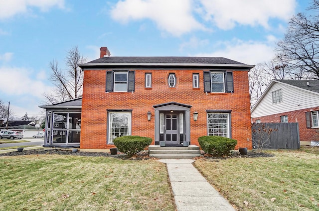 colonial-style house with a sunroom and a front yard