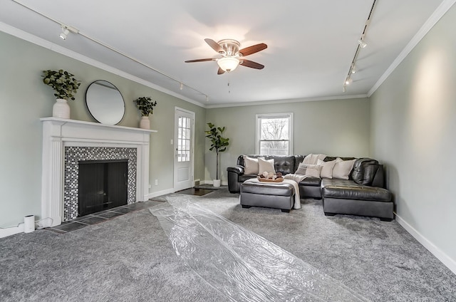 living room with crown molding, a fireplace, rail lighting, and dark colored carpet