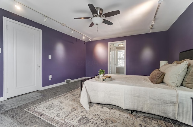 bedroom featuring rail lighting, ceiling fan, and carpet