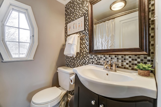 bathroom featuring vanity, decorative backsplash, and toilet