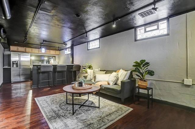 living room with rail lighting, plenty of natural light, and dark hardwood / wood-style floors