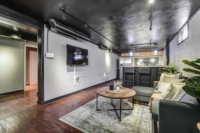 unfurnished living room featuring rail lighting and hardwood / wood-style floors