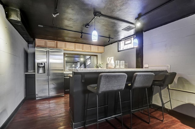 interior space featuring stainless steel refrigerator with ice dispenser, rail lighting, dark hardwood / wood-style floors, and light brown cabinets