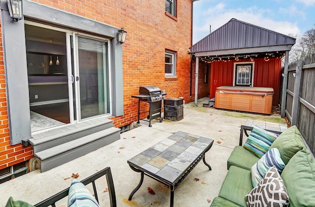 view of patio / terrace with a hot tub, a gazebo, and grilling area