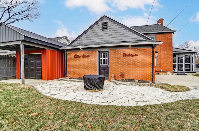 back of house featuring a garage, a patio, and a yard