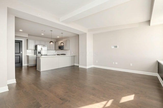 kitchen featuring stainless steel appliances, dark wood-type flooring, pendant lighting, and beam ceiling