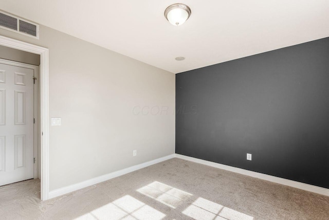 unfurnished room featuring light colored carpet, visible vents, and baseboards