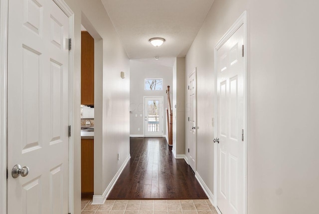 hall with light wood-style floors and baseboards