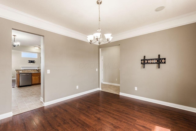 unfurnished room with crown molding, baseboards, a notable chandelier, and wood finished floors