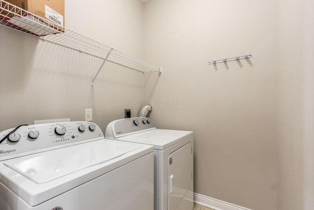 washroom featuring laundry area, washer and clothes dryer, and baseboards