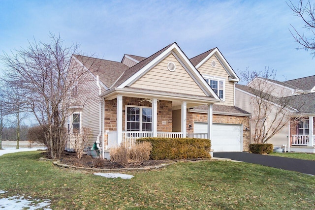 view of front of property featuring a porch, a front yard, a garage, stone siding, and driveway