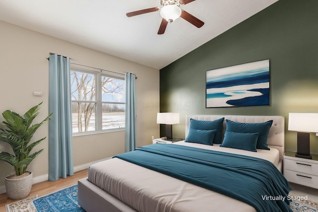 bedroom with light wood finished floors, baseboards, vaulted ceiling, and a ceiling fan