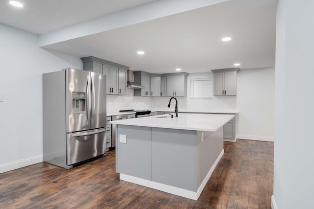 4874 Ridge St, Columbus, OH 43207 - kitchen with sink, gray cabinetry, stainless steel fridge, a kitchen island with sink, and wall chimney exhaust hood
