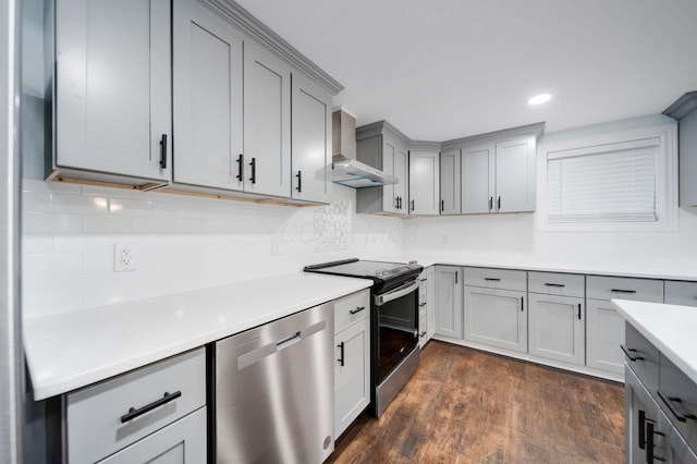 4874 Ridge St, Columbus, OH 43207 - kitchen featuring appliances with stainless steel finishes, decorative backsplash, dark hardwood / wood-style flooring, and wall chimney exhaust hood