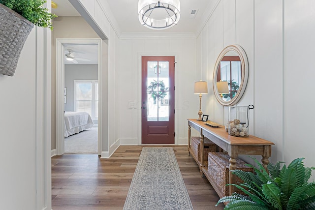 entrance foyer with hardwood / wood-style flooring and ornamental molding