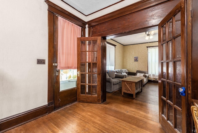 sitting room with wood-type flooring, crown molding, and french doors