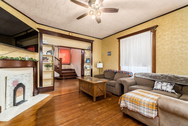 living room with ornamental molding, dark wood-type flooring, and ceiling fan