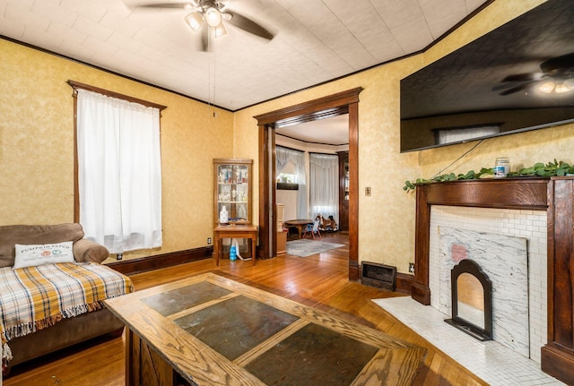 living room featuring crown molding, ceiling fan, and hardwood / wood-style floors