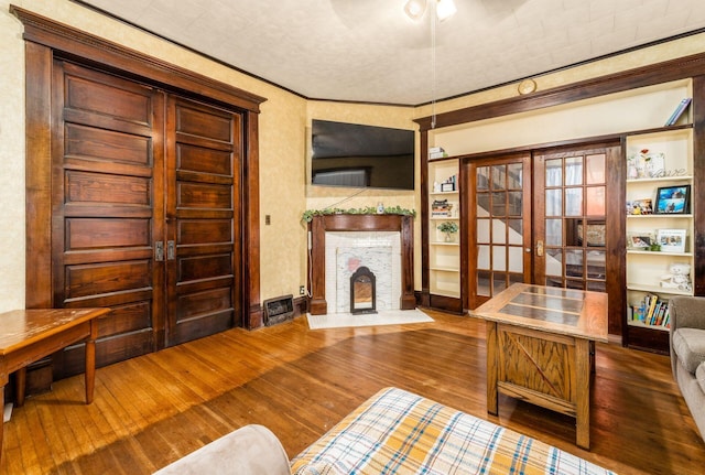 office with hardwood / wood-style flooring, ornamental molding, and french doors