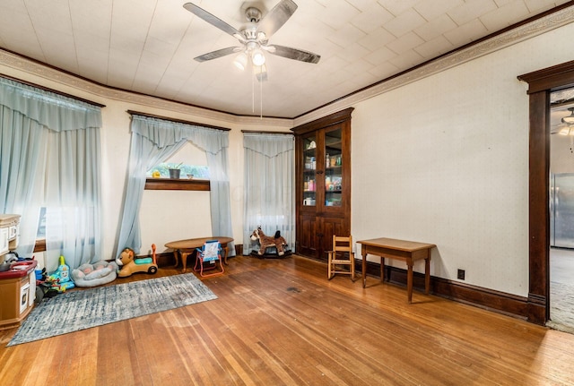 interior space featuring crown molding, ceiling fan, and wood-type flooring