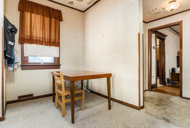 dining space featuring crown molding and light colored carpet