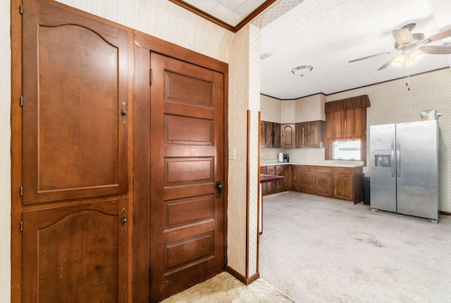 kitchen with light carpet, stainless steel fridge, ornamental molding, and ceiling fan