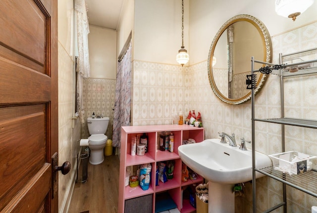 bathroom with hardwood / wood-style floors, tile walls, and toilet