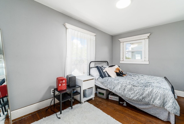 bedroom with dark hardwood / wood-style floors