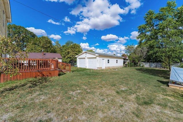 view of yard with a wooden deck, a garage, and an outdoor structure