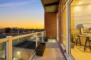 balcony at dusk featuring a water view