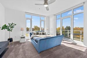 carpeted bedroom featuring floor to ceiling windows, access to outside, and ceiling fan