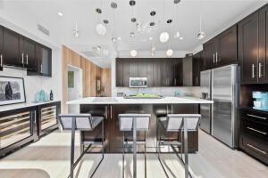 kitchen with appliances with stainless steel finishes, a kitchen bar, decorative light fixtures, and a center island