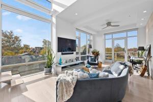 living room featuring hardwood / wood-style floors, a wealth of natural light, and ceiling fan