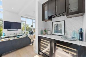 bar with expansive windows, beverage cooler, and light hardwood / wood-style floors