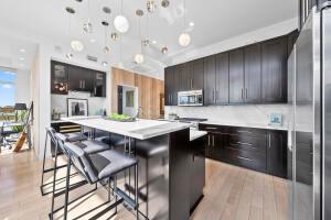 kitchen with a breakfast bar area, decorative light fixtures, a center island, dark brown cabinets, and appliances with stainless steel finishes