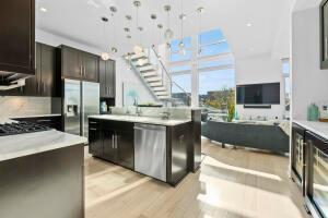 kitchen featuring dark brown cabinets, hanging light fixtures, light wood-type flooring, a kitchen island, and stainless steel appliances