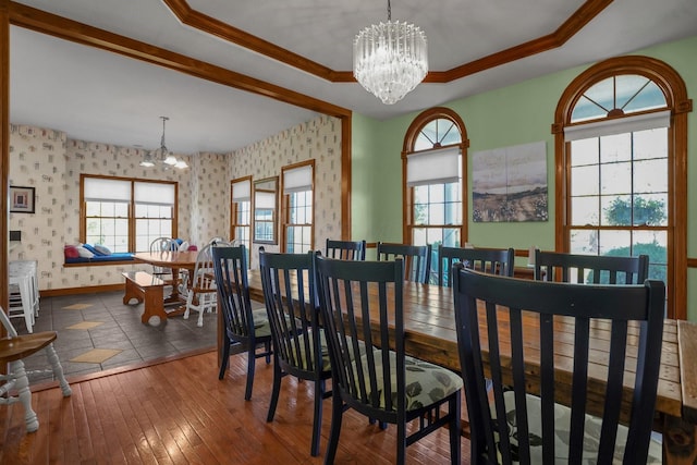 dining room featuring a healthy amount of sunlight, a tray ceiling, and a chandelier