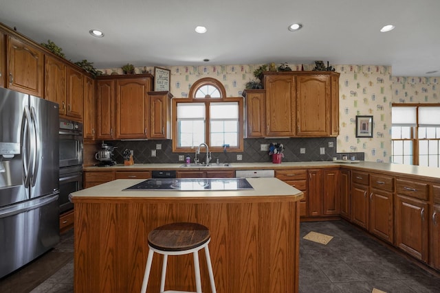 kitchen featuring kitchen peninsula, sink, a kitchen island, and black appliances