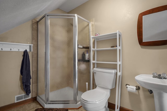 bathroom with vaulted ceiling, a shower with shower door, and toilet