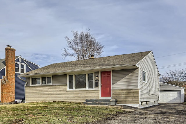 view of front facade with a garage, an outdoor structure, and a front lawn