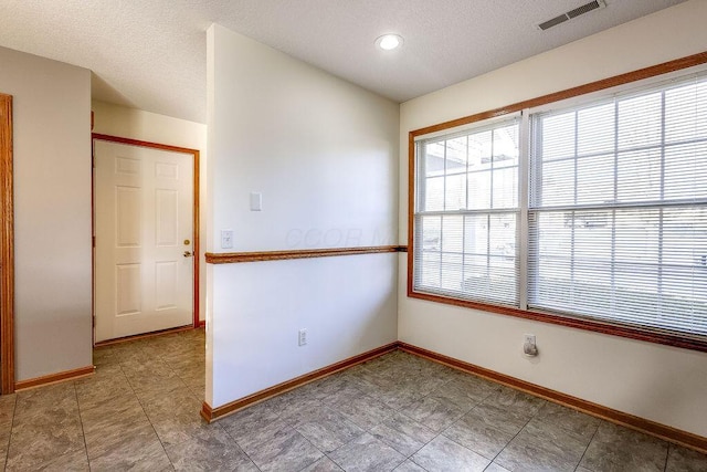 unfurnished room featuring a textured ceiling