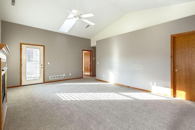 empty room with high vaulted ceiling, light colored carpet, ceiling fan, and a skylight