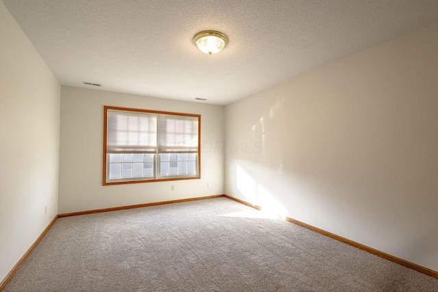 unfurnished room with a textured ceiling and carpet flooring