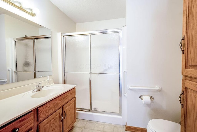 bathroom featuring an enclosed shower, vanity, and toilet