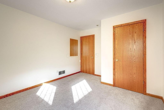 unfurnished bedroom featuring light carpet