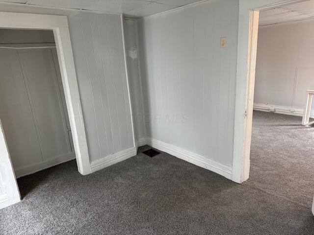 unfurnished bedroom with dark carpet