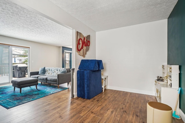 living room with dark hardwood / wood-style flooring and a textured ceiling