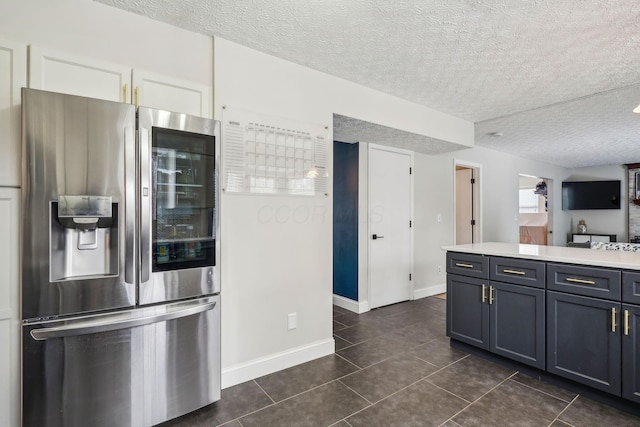 kitchen featuring gray cabinetry, stainless steel fridge with ice dispenser, a textured ceiling, dark tile patterned flooring, and white cabinets