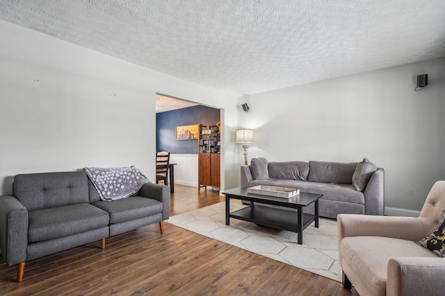 living room with a textured ceiling and light hardwood / wood-style floors