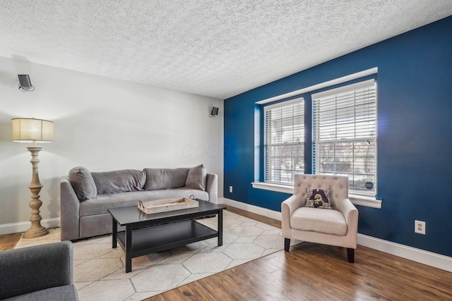 living room with a textured ceiling and light hardwood / wood-style flooring